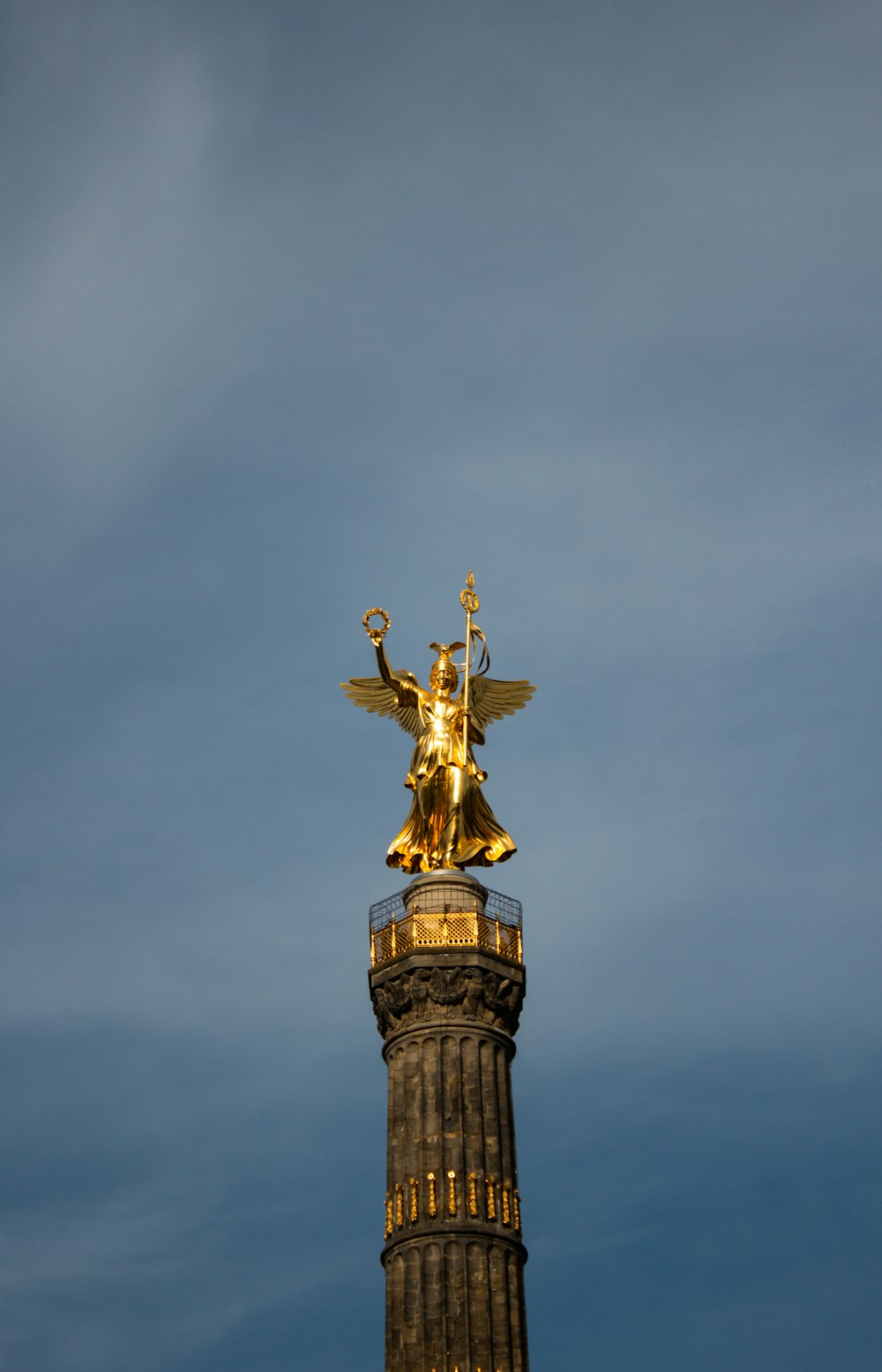 Una estatua dorada en la cima de una torre alta