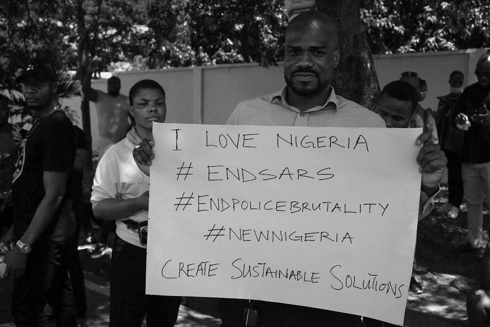 a man holding a sign in front of a group of people