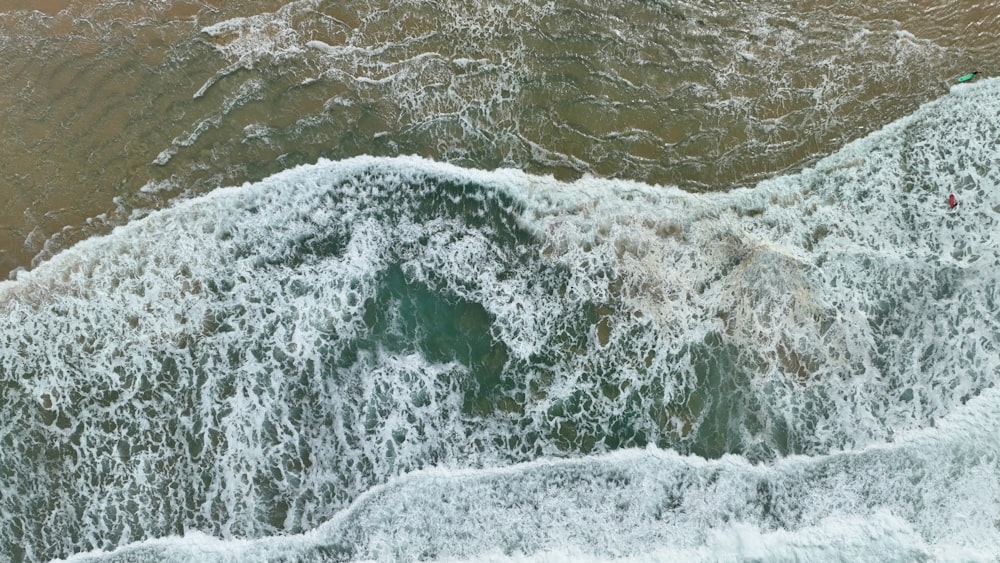 a man riding a wave on top of a surfboard