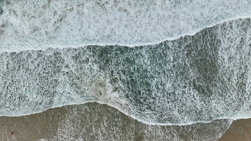 an aerial view of a beach with waves crashing on it