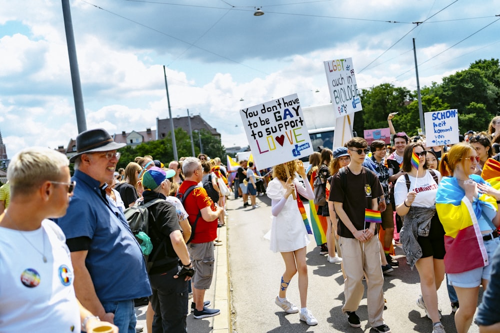 a group of people walking down a street holding signs