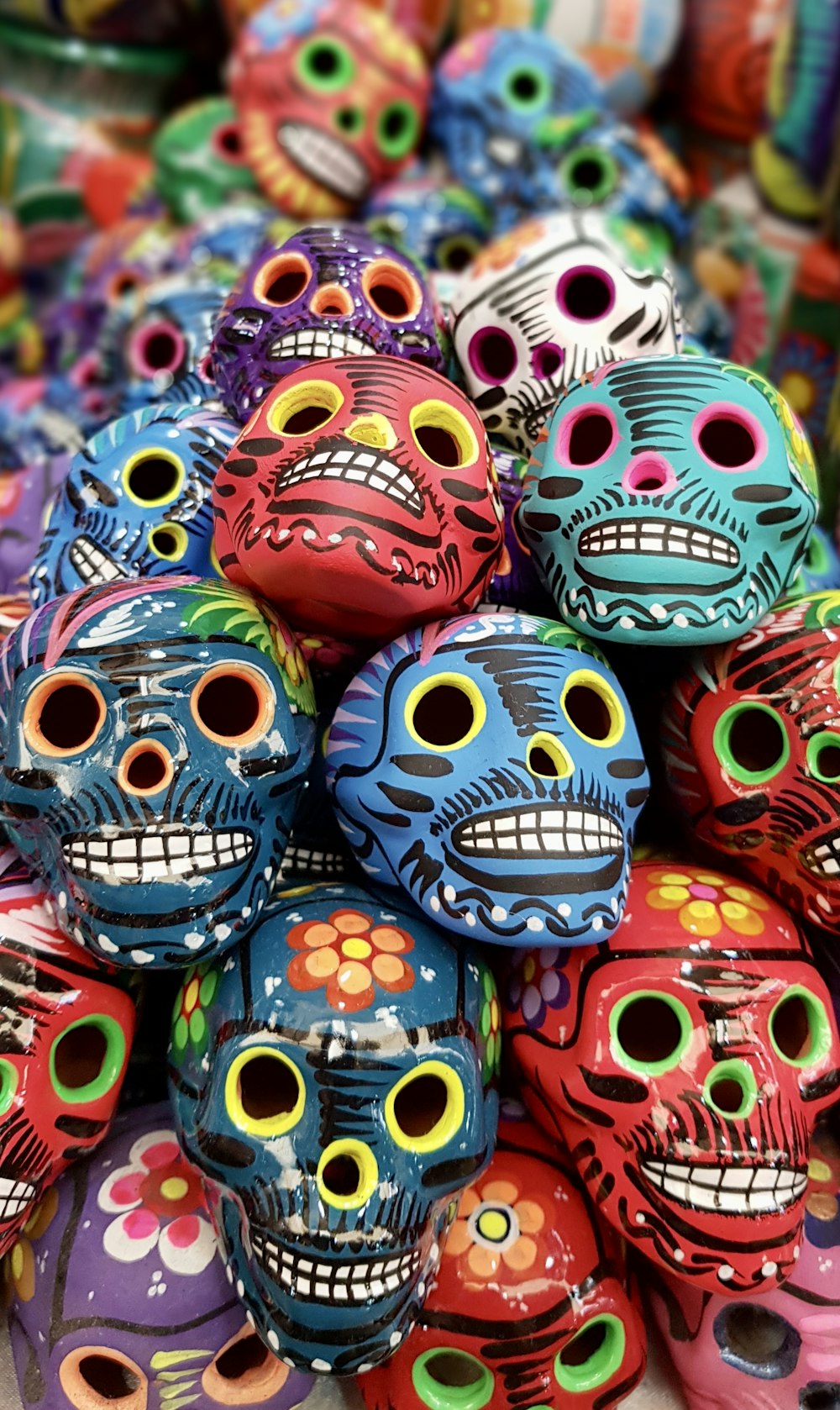 a pile of colorful skulls sitting on top of a table
