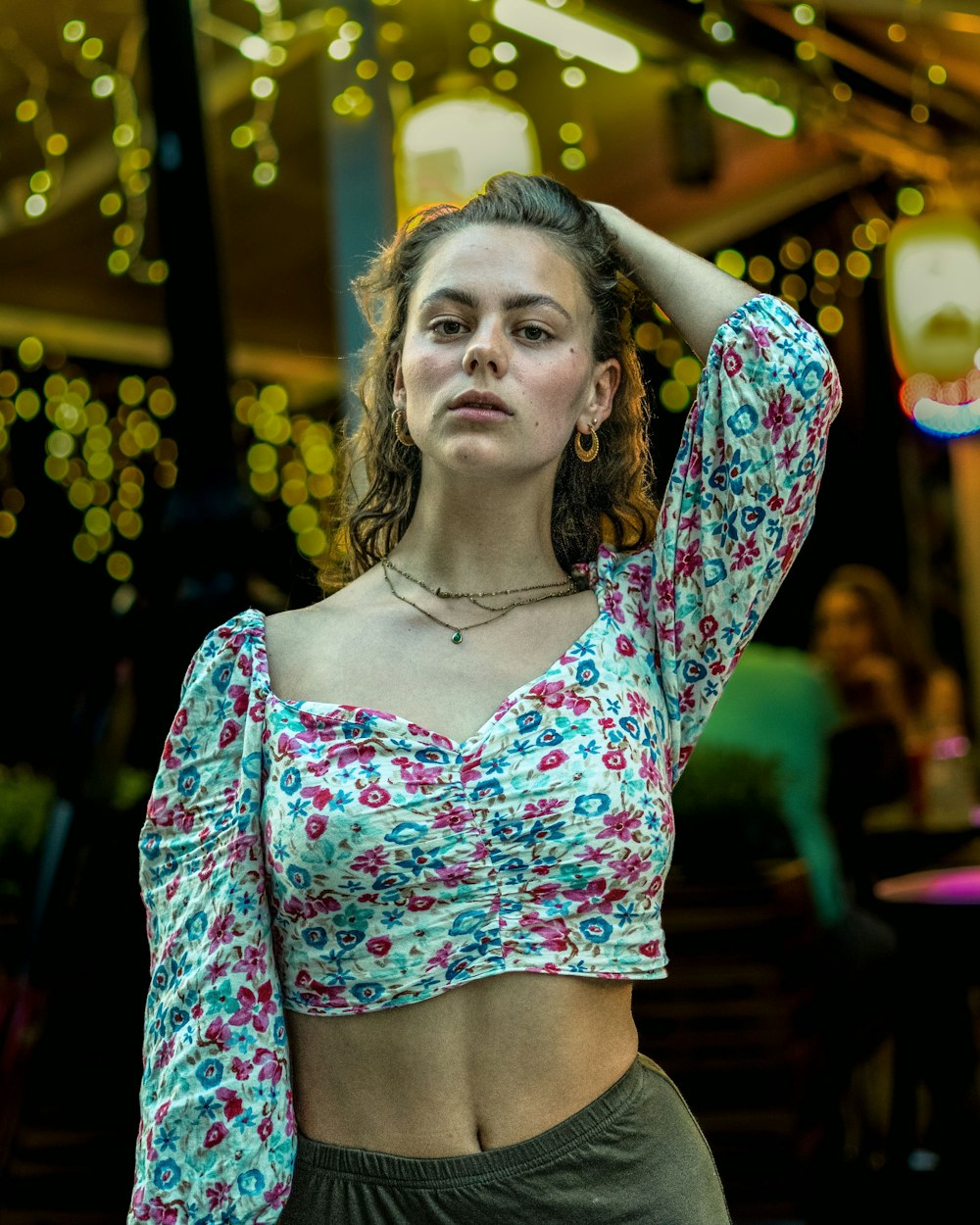 a woman in a floral crop top posing for a picture