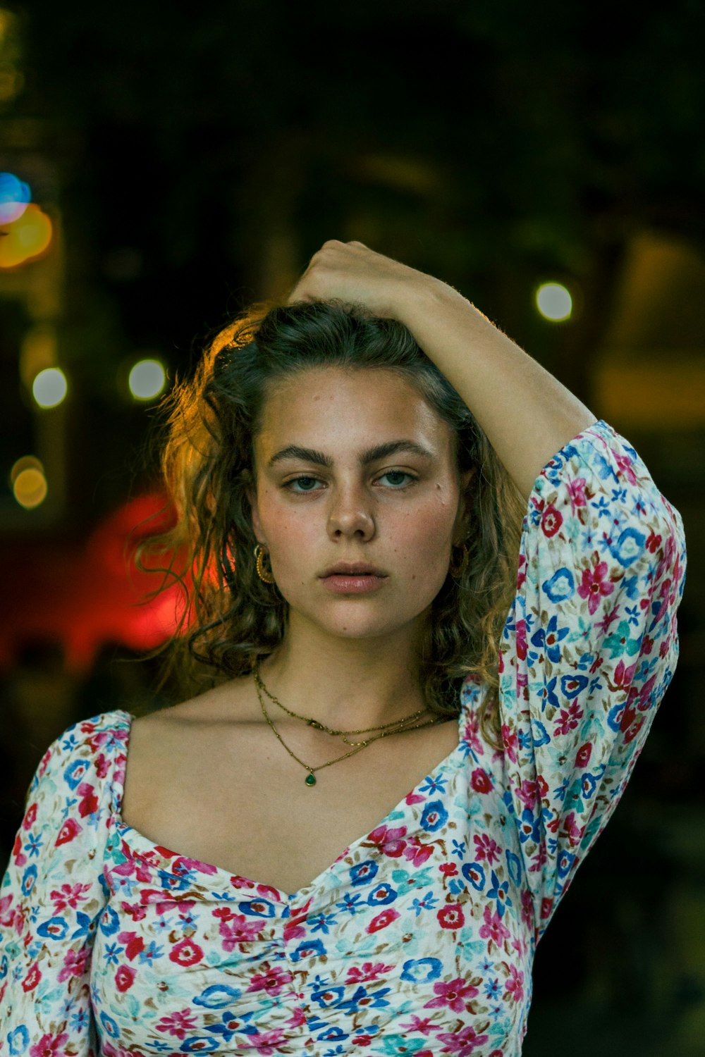 a woman in a floral top is holding her head