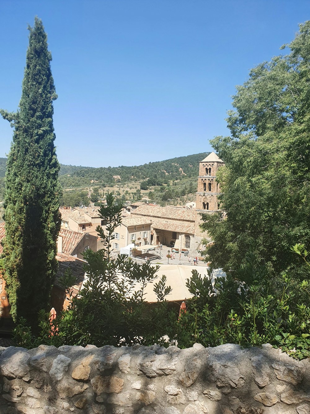 a stone wall with trees and buildings in the background