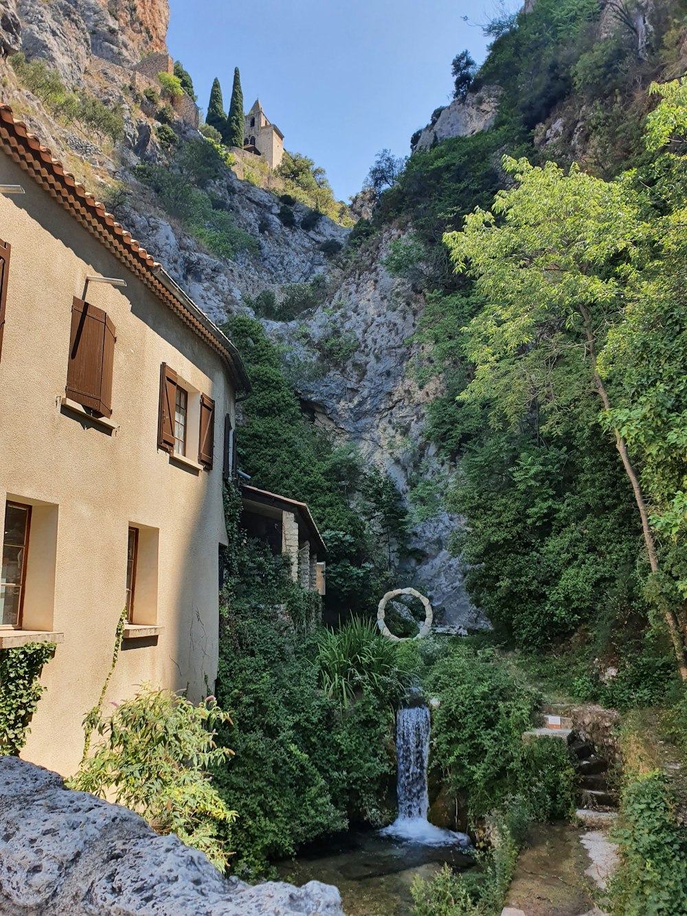 Una casa con una cascada frente a ella