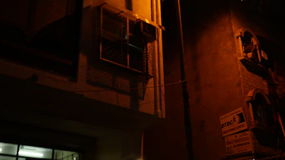 A locksmith technician unlocking a commercial building door under warm orange and purple lighting.