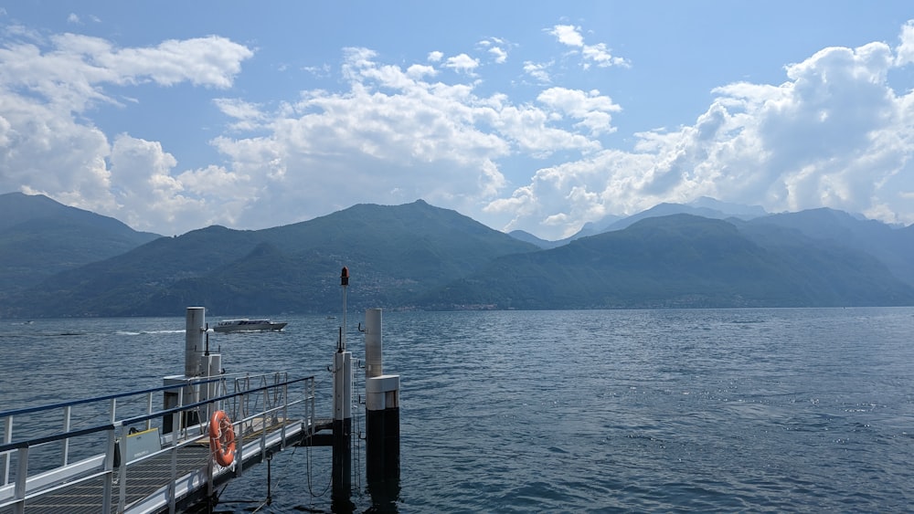 a pier on a lake with mountains in the background