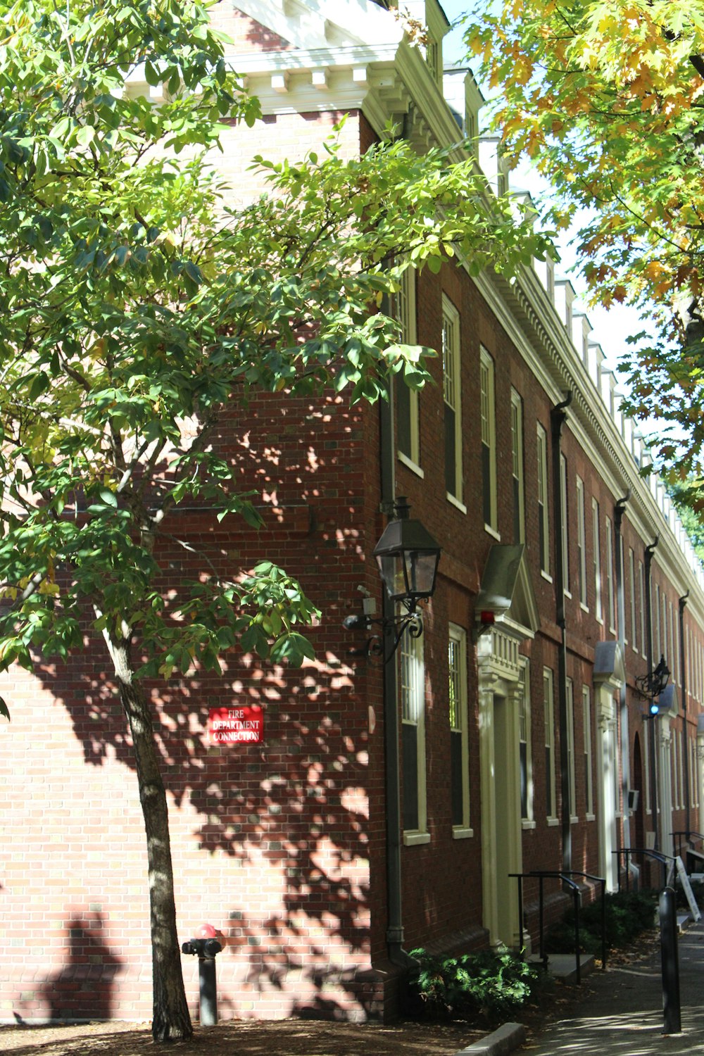 a red brick building sitting next to a tree