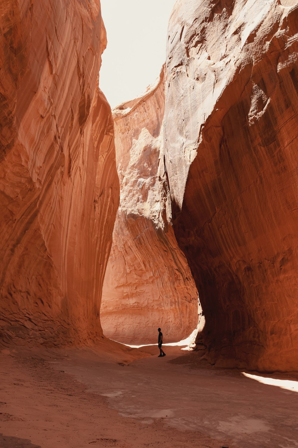 a person standing in the middle of a narrow canyon