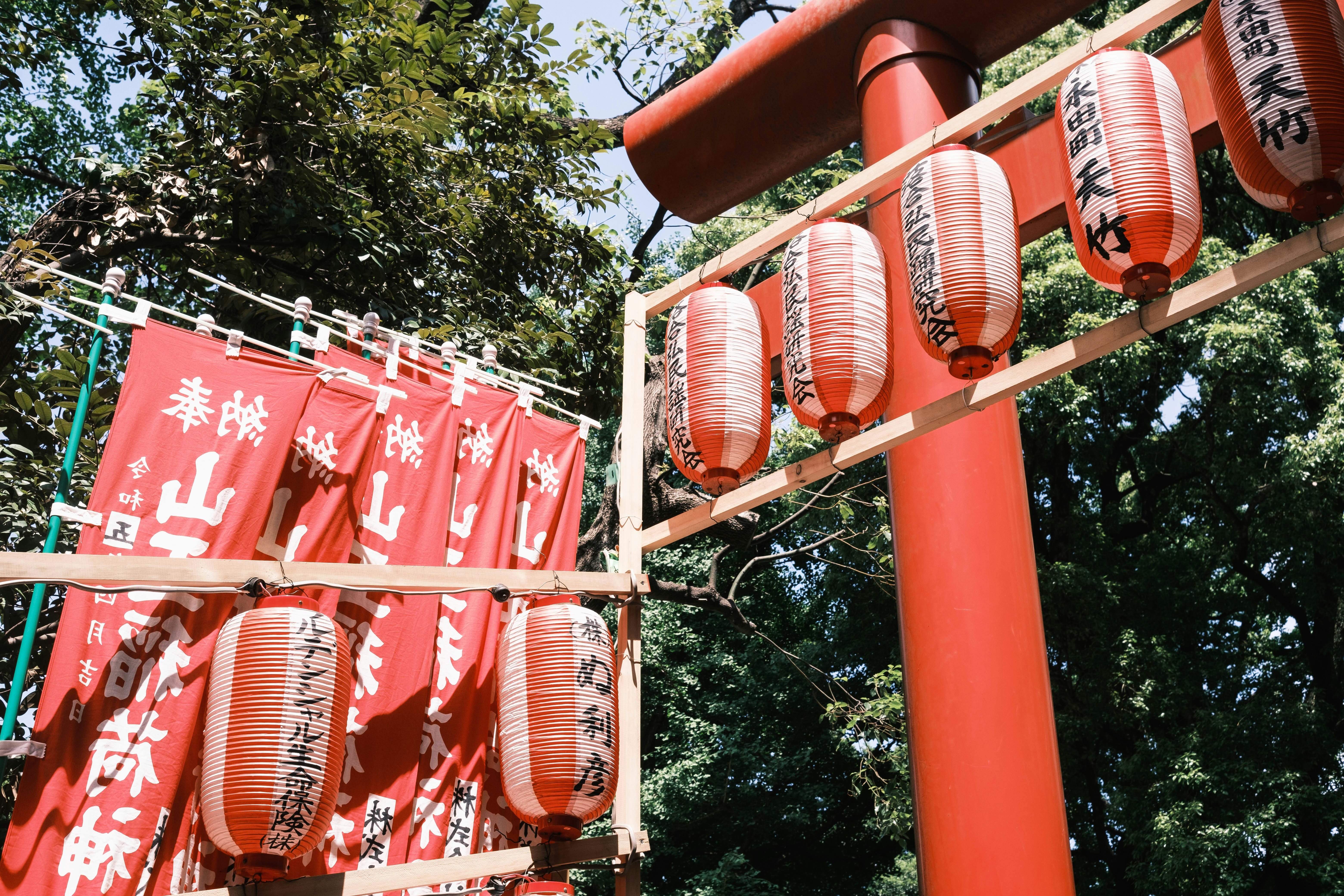 a group of red lanterns hanging from the side of a pole
