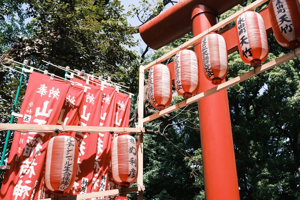 a group of red lanterns hanging from the side of a pole