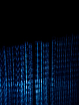 Vertical blue digital lines resembling binary code or data streams on a dark background create a visually striking and abstract pattern.