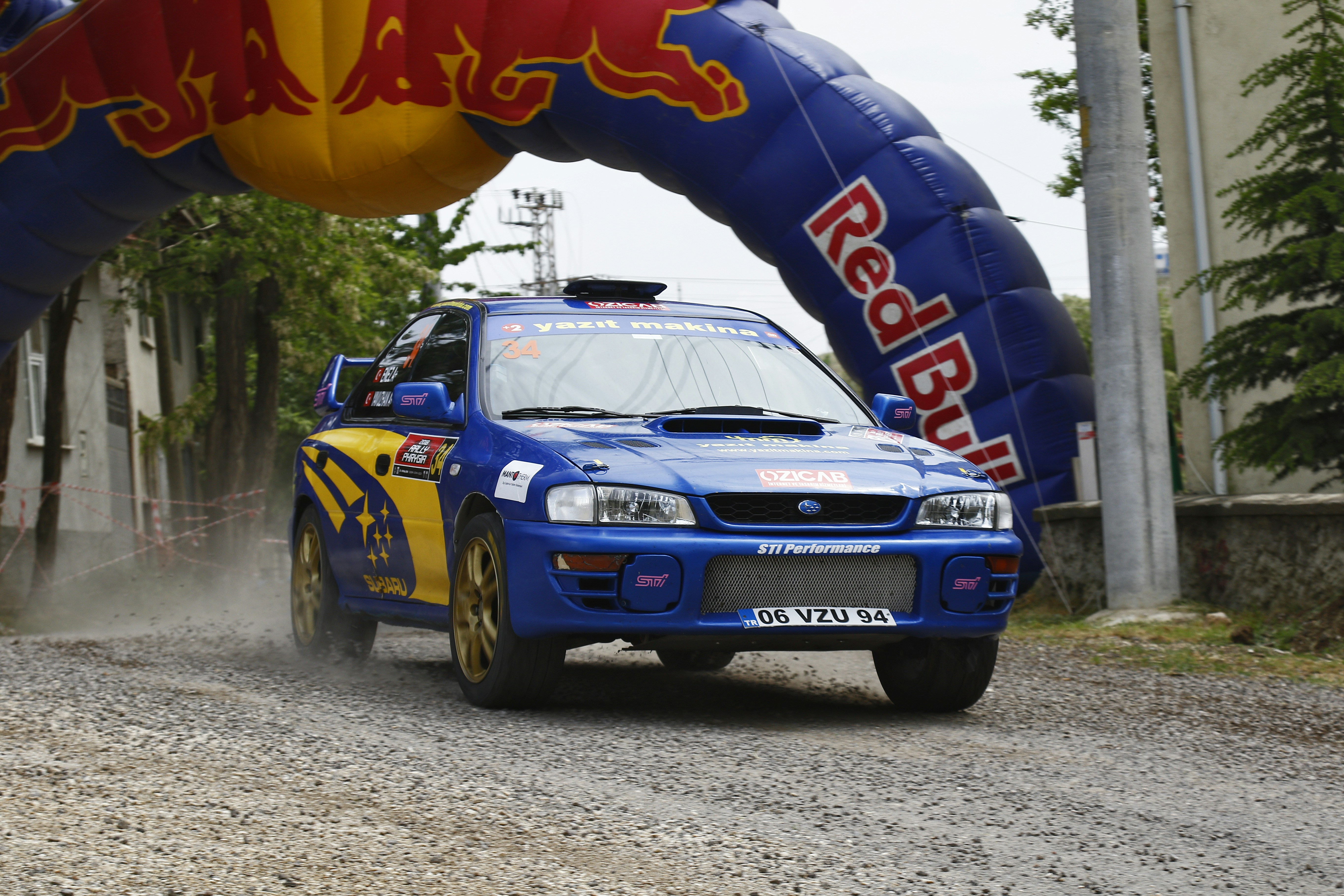 A rally car driving down a dirt road