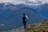 Excited woman with a backpack overlooking a misty Himalayan mountain range.