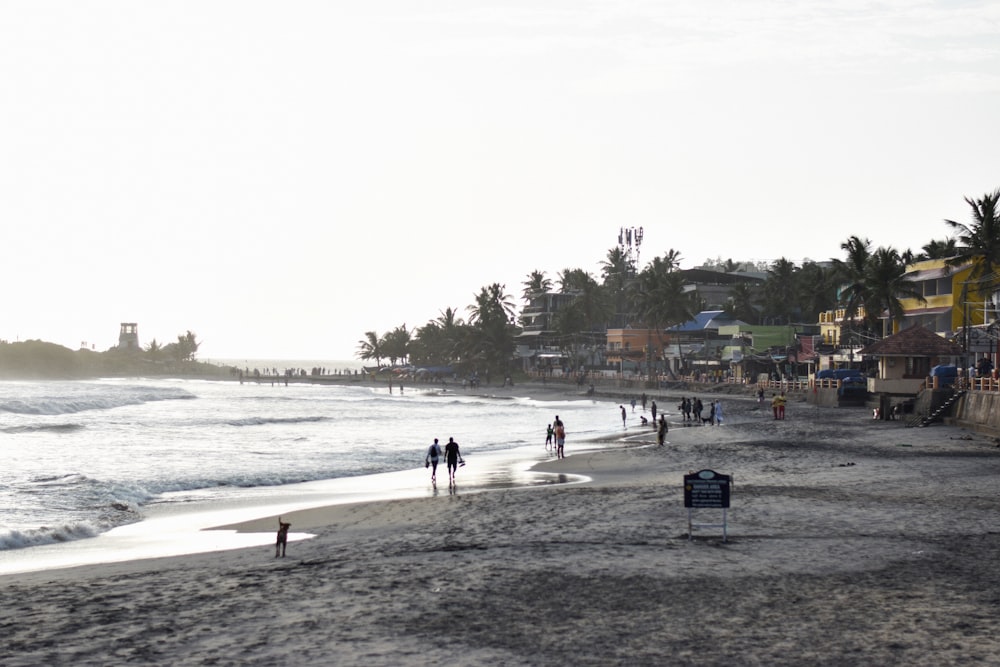 a group of people standing on top of a sandy beach