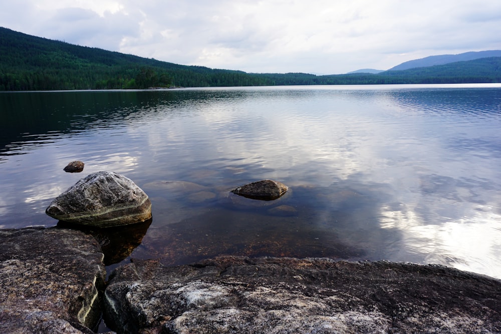 a lake with some rocks in the water