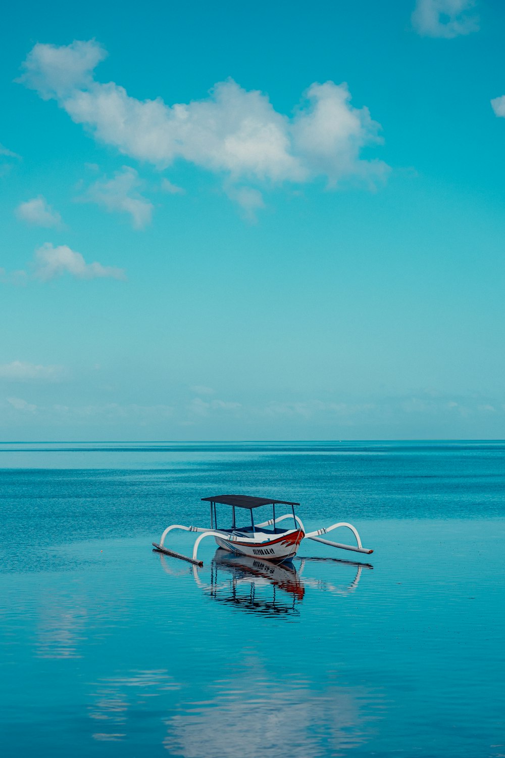 a small boat floating on top of a large body of water