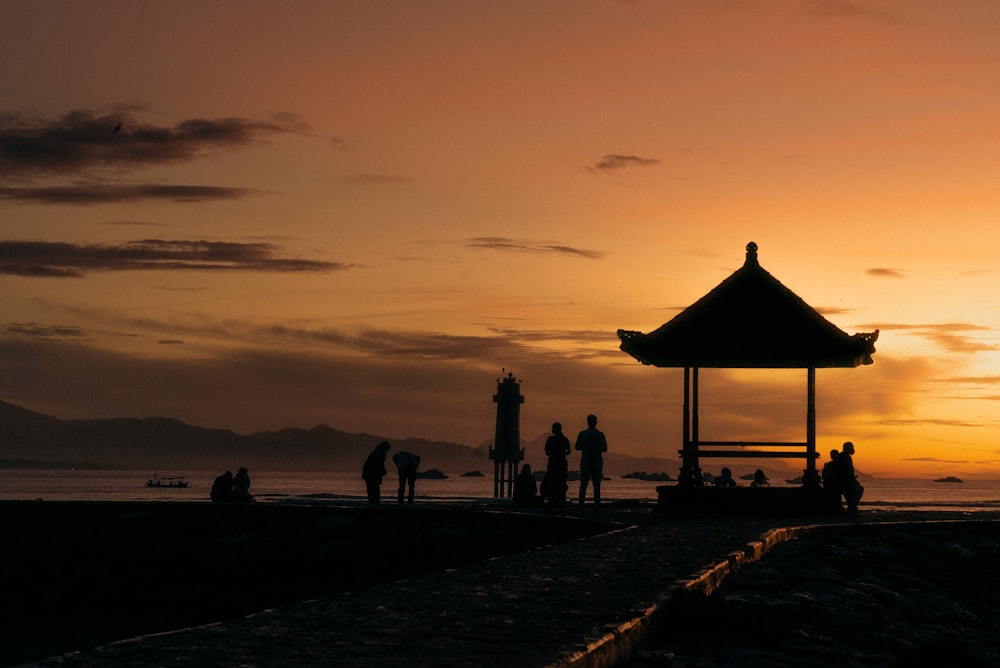 a group of people standing on top of a sandy beach