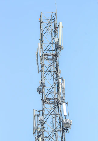 Condition monitoring equipment installed on a power grid tower against a clear blue sky.