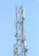 A tall metal communication tower with various antennas and equipment installed on it against a clear blue sky.