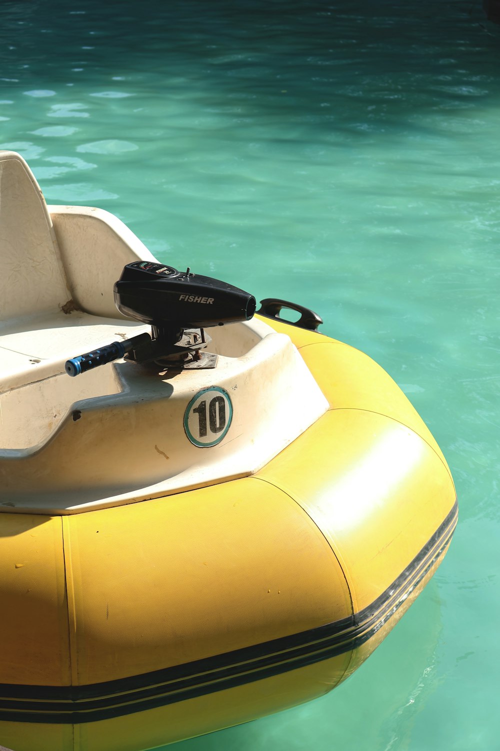 a yellow and white boat floating in a body of water