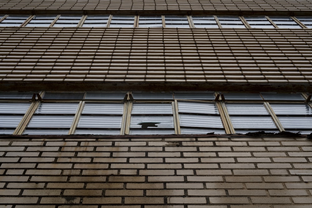 a brick building with several windows and a bird on the window sill