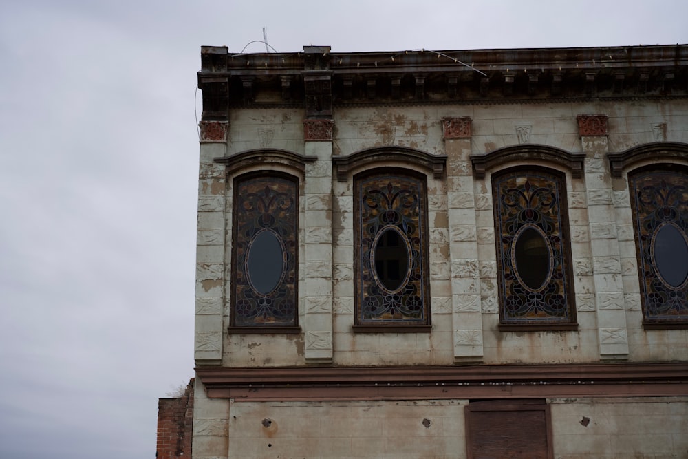 um edifício alto com três janelas e um relógio