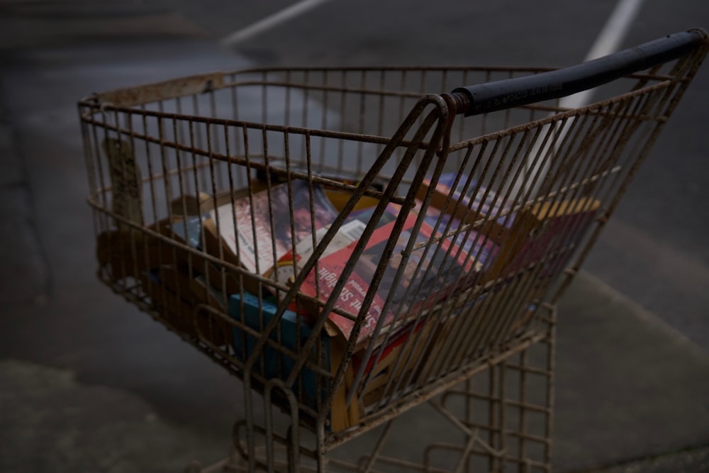 a shopping cart filled with books on the side of the road