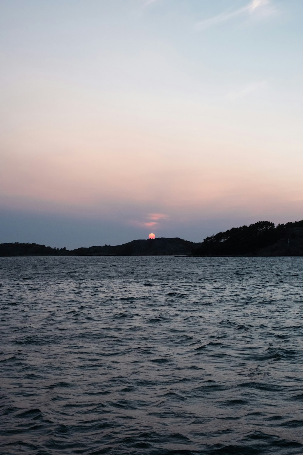 a body of water with a sunset in the background