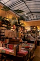 a room filled with lots of books and plants