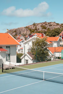 A lively tennis court with players enjoying a friendly match under clear skies.