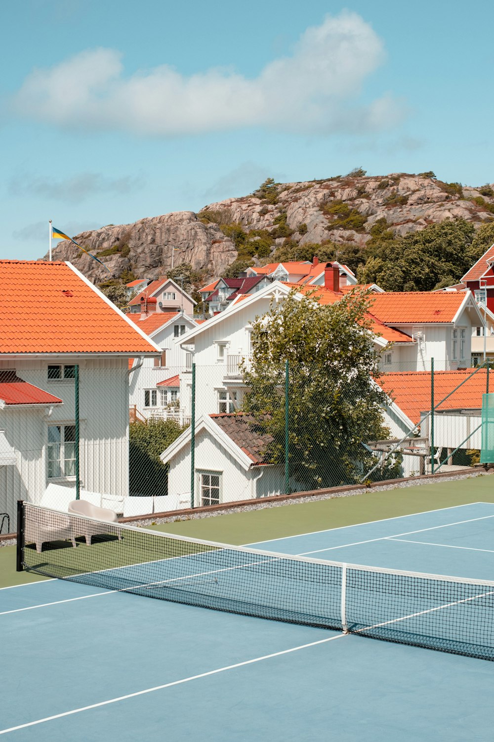 a tennis court with houses in the background