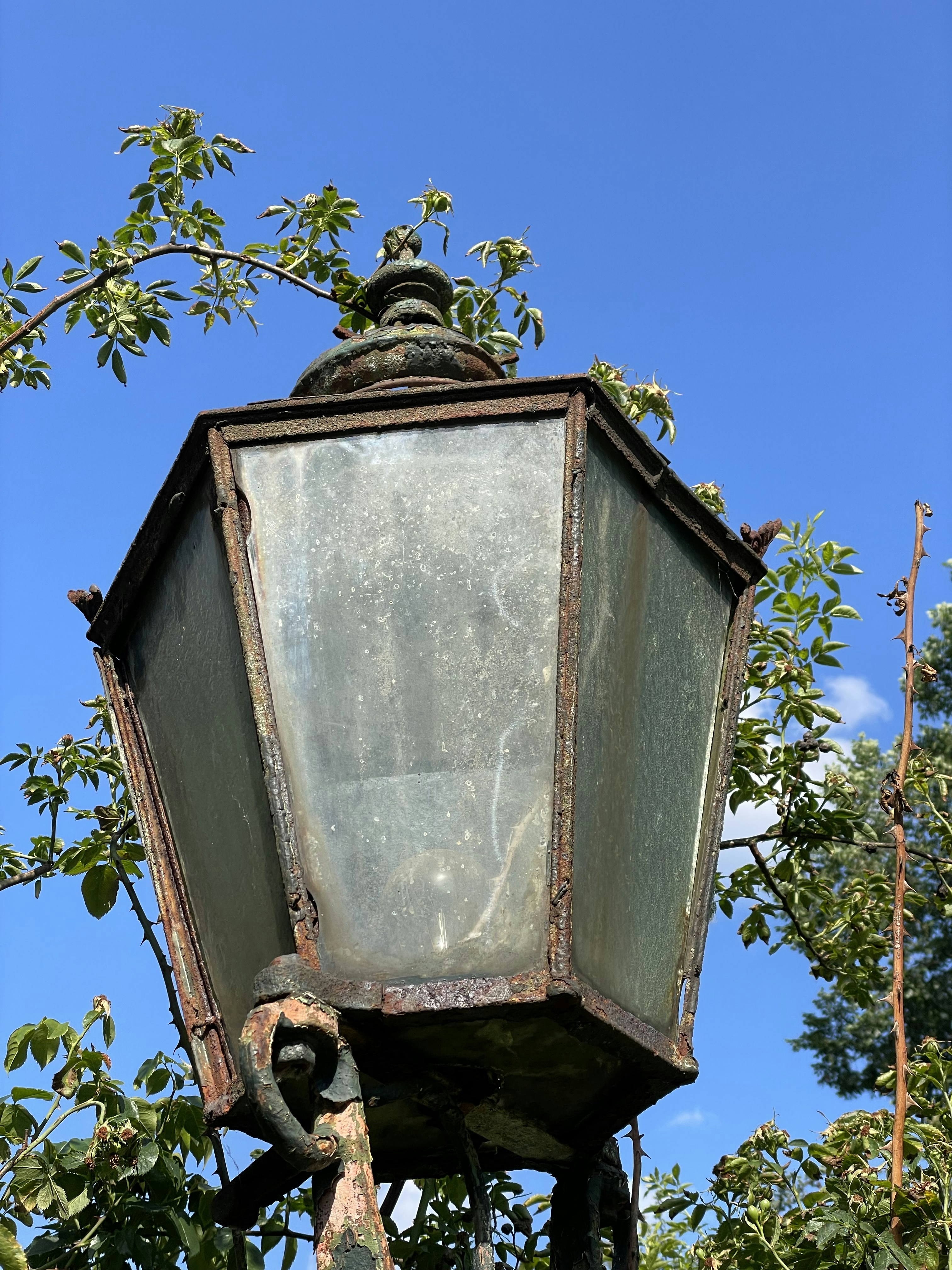 an old fashioned street light with a blue sky in the background