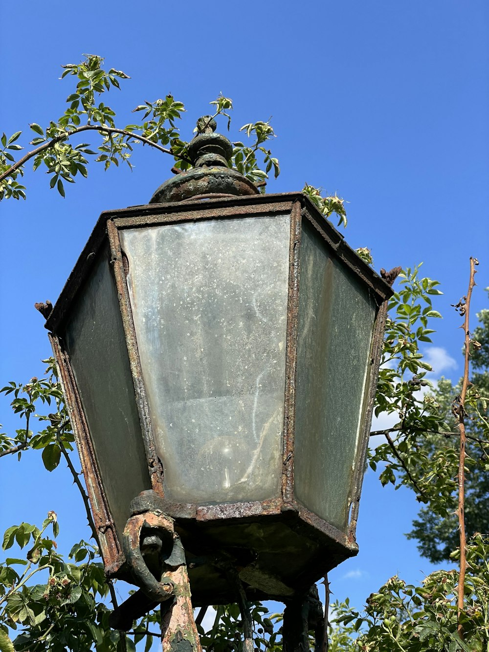 an old fashioned street light with a blue sky in the background