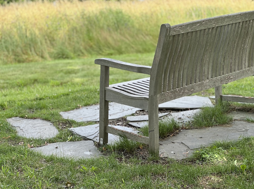 a wooden bench sitting on top of a lush green field