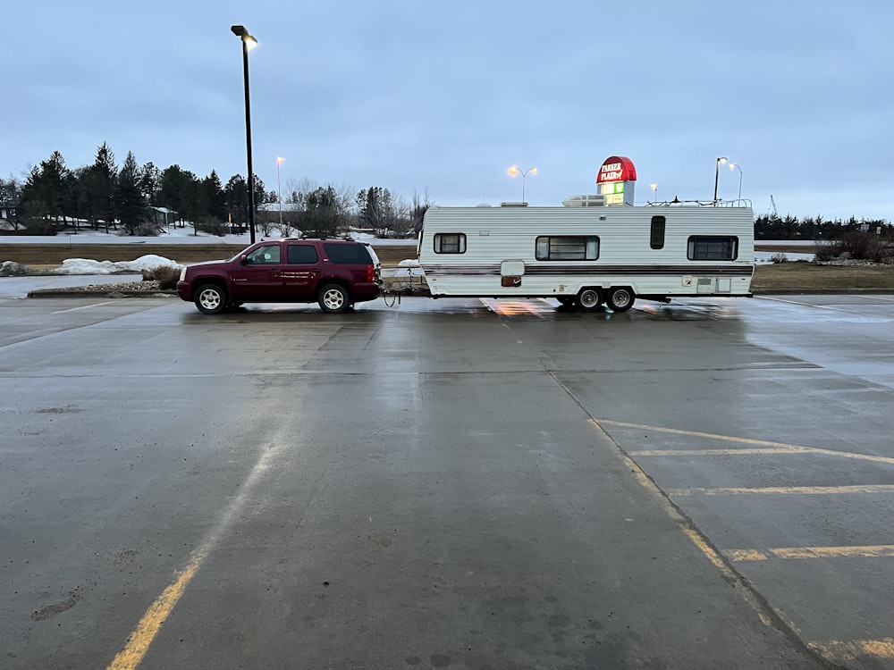 a red truck towing a trailer in a parking lot
