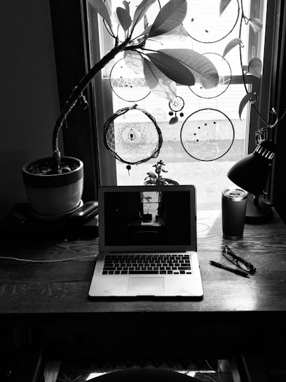 A cozy workspace with a laptop, notebooks filled with fantasy story ideas, and handcrafted items from the Etsy shop.