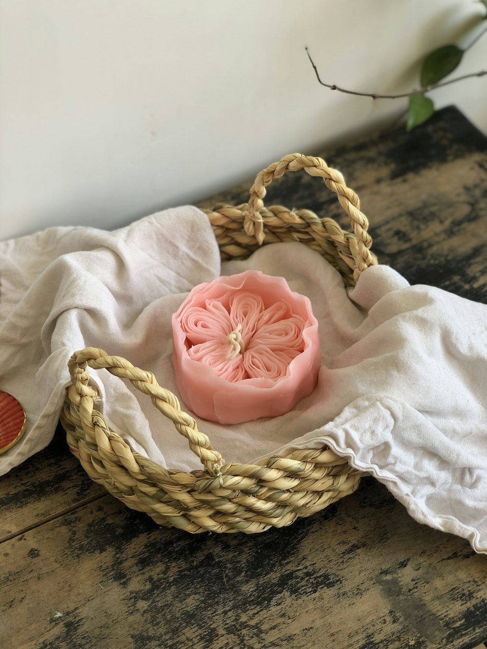a basket with a pink flower on top of it
