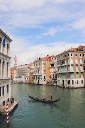 a gondola in the middle of a canal with buildings in the background