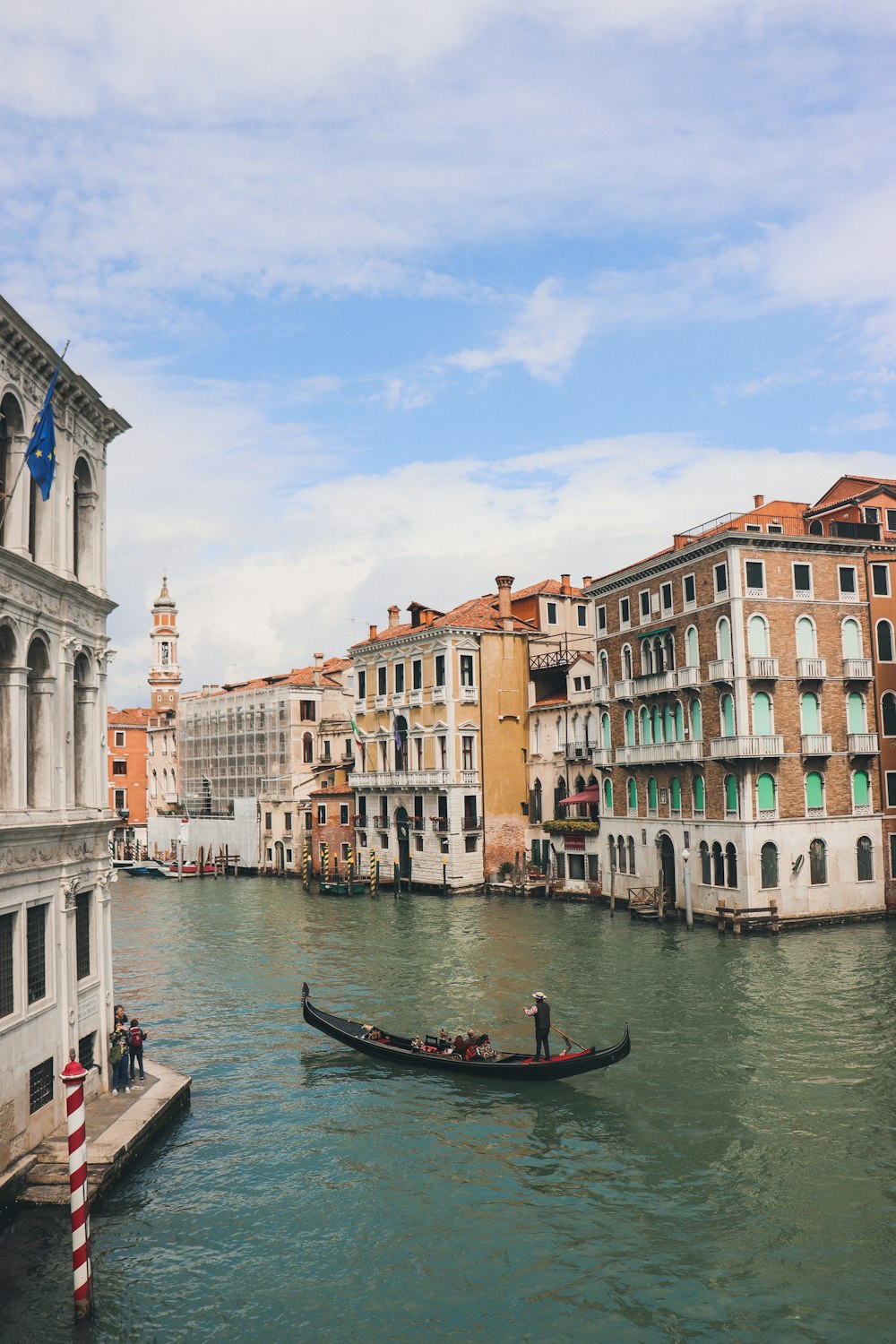 a gondola in the middle of a canal with buildings in the background