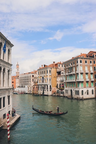 a gondola in the middle of a canal with buildings in the background