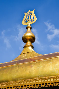 A technician polishing the golden finial (alem) atop a mosque minaret.