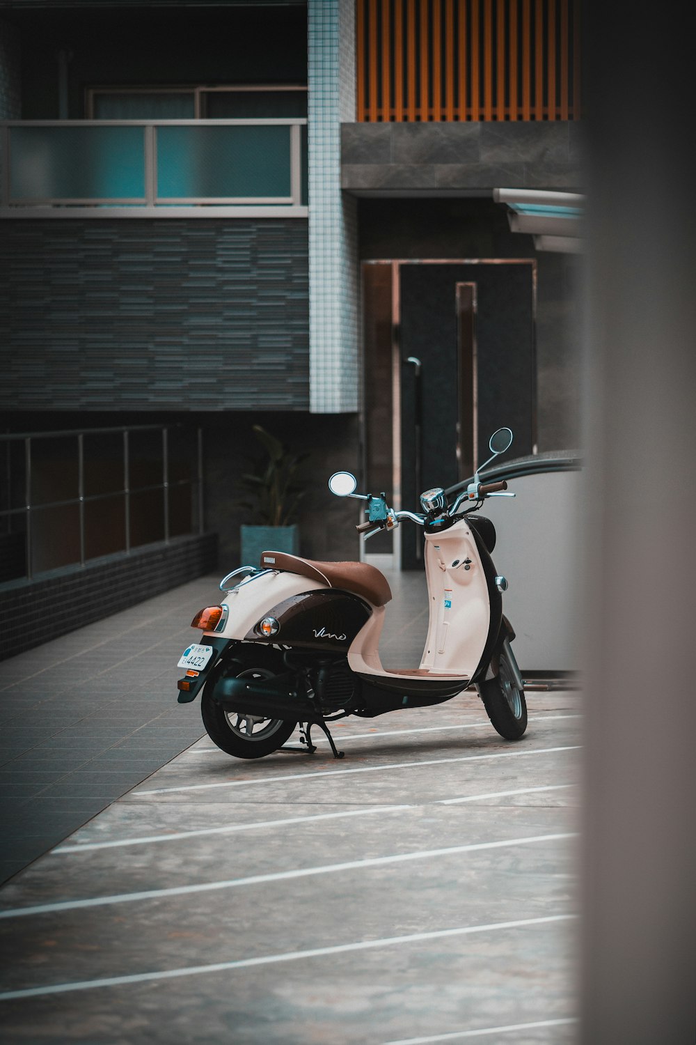 Un scooter estacionado en un estacionamiento al lado de un edificio