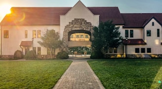 a large white house sitting on top of a lush green field