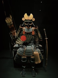 a samurai sitting on a chair holding a sword