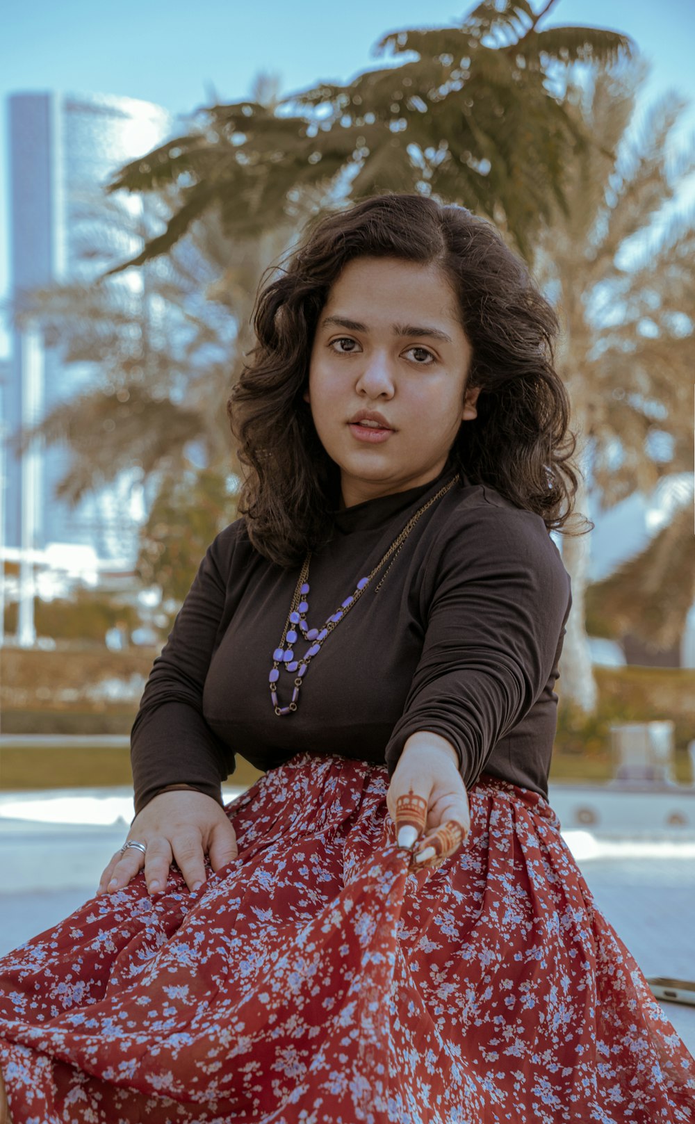 a woman sitting on a bench in a dress