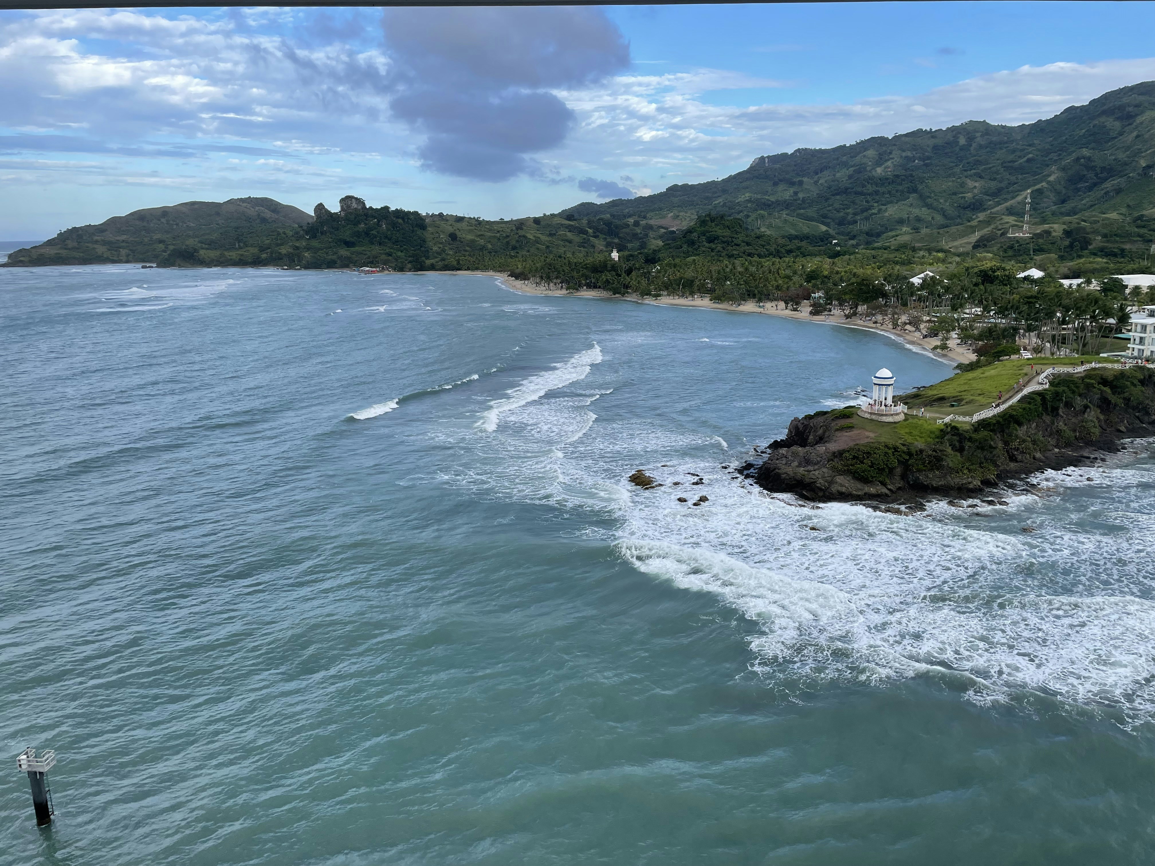 an aerial view of a body of water with a lighthouse in the distance