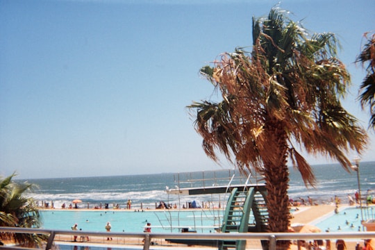 Technicians installing pool equipment at a coastal resort under clear blue skies.