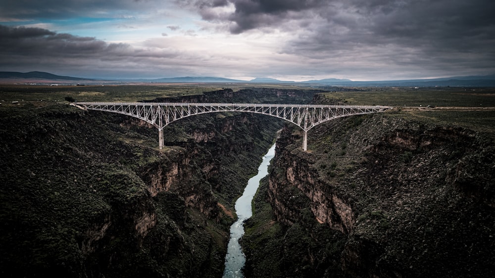 a bridge over a canyon with a river below